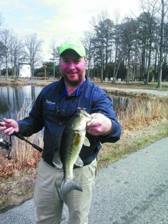 Rich Dennison, manager of Tochterman's Fishing Tackle in Baltimore, holds up a nice largemouth bass he caught at an Eastern Shore pond. (Photo courtesy of Chris D. Dollar)