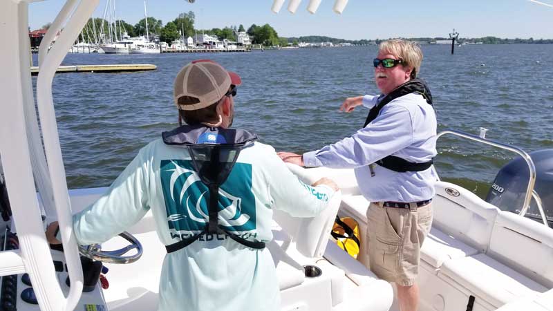 John gives Eric boat handling tips.