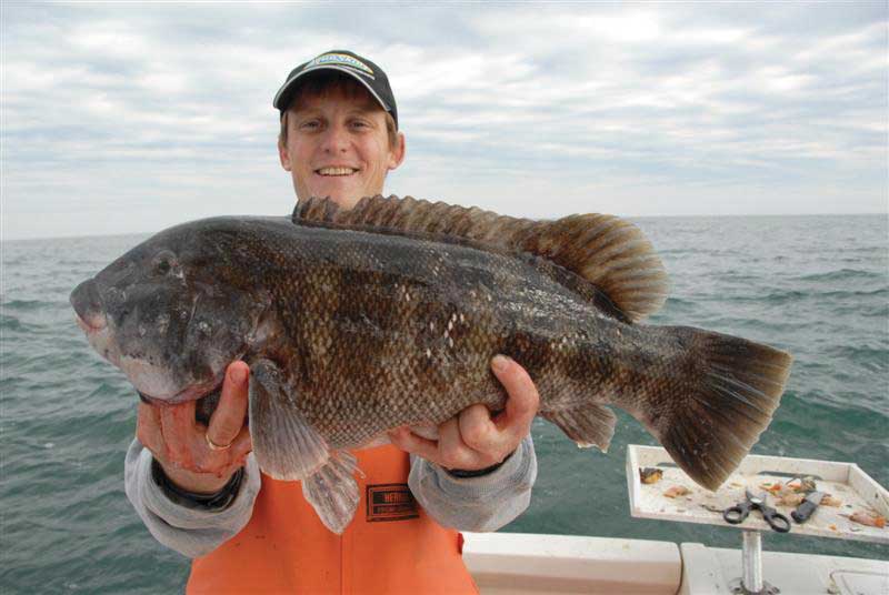 Ric Burnley shows off a big tog. No sunglasses, and the sun is on the fish.