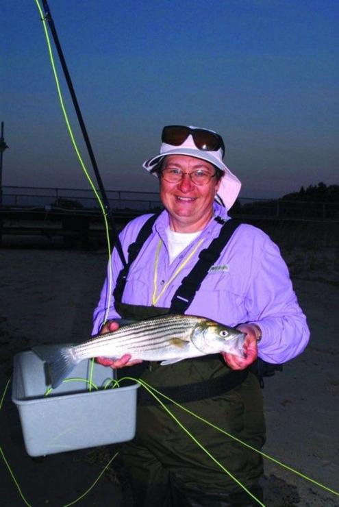 Fly fishing instructor Dianne Tidy with schoolie striper caught at Cape Henlopen Flats in Lewes, Delaware. Fly fishing instructor Dianne Tidy with schoolie striper caught at Cape Henlopen Flats in Lewes, Delaware.