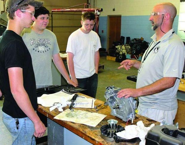 Teacher Dave Fawley (R), explains the next step in rebuilding an engine to students (L to R) Austin Angermeir, Justin Ring, and Austin Jackson in the shop at the Center for Applied Technology South in Edgewater, MD. Photo by Rick Franke