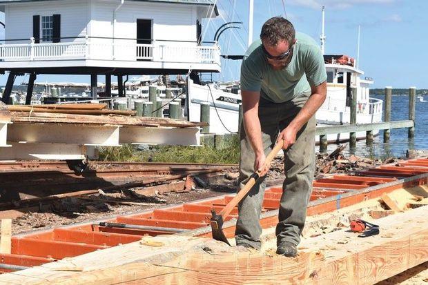 Joe Connor, shipwright at Chesapeake Bay Maritime Museum in St. Michaels, MD, begins shaping one of the 50-foot logs to be used in the rebuilding of the bugeye Edna Lockwood.