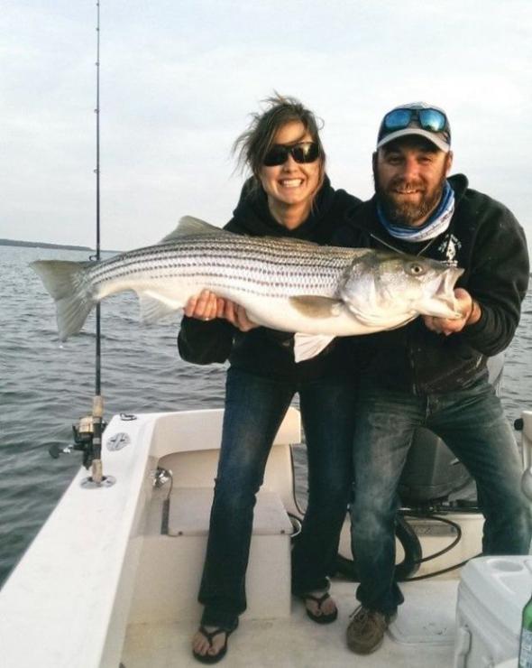 Captain Jeff Lewatowski of Lew’s Fly Angler Guide Service and his wife Megan with a fine striper. Photo courtesy of Lew’s Fly Angler