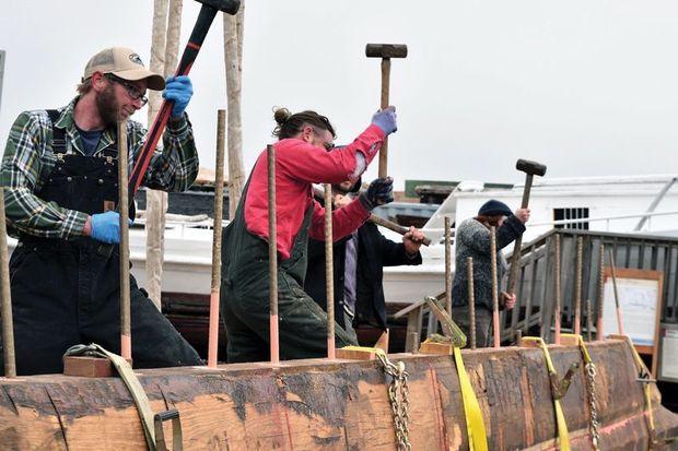 Shipwright apprentice Michael Allen (left) and CBMM boatyard manager Michael Gorman assist in the pinning together of the nine logs for the bottom of the bugeye Edna P Lockwood at the Chesapeake Bay Maritime Museum boatyard in St. Michaels.