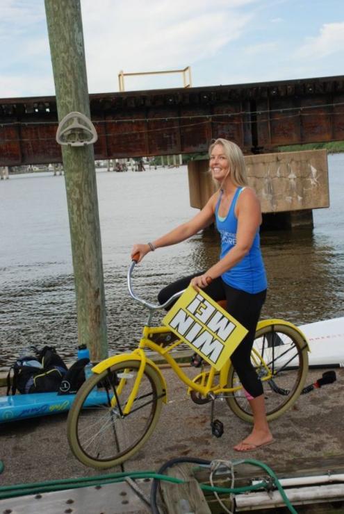 B'More SUP owner Jessie Benson with the beach cruiser that was raffled off.