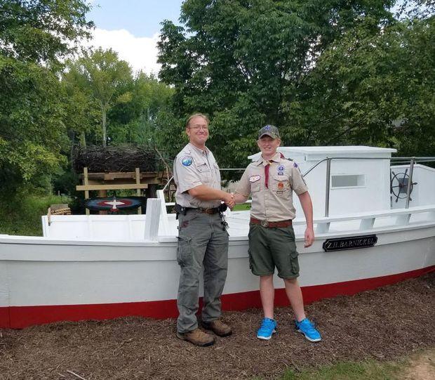 Marshy Point Senior Naturalist Ben Porter (left) with Zachary Barnickel. Behind the skipjack is a replica bald eagle nest, constructed by Troop 355. Photo courtesy Marshy Point Nature Center
