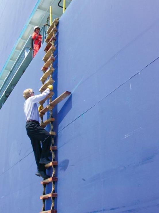 Pilot Mark Fithian climbs Jacob's ladder on the way to the job. Photo by Art Pine