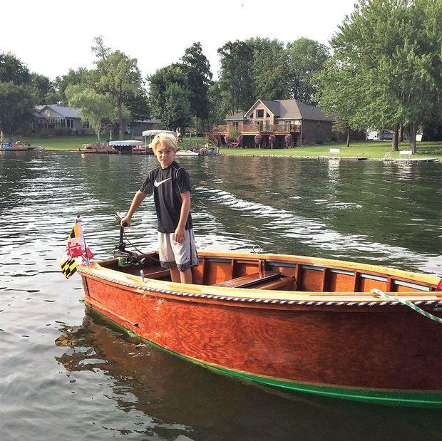 Huckleberry Finn, a mahogany skiff, being test run by her 10 year old captain after being restored at Classic Watercraft Restoration in Annapolis, MD.