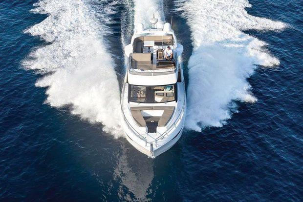 The 460 Fly shows her deck and flying bridge layout as she cruises under a bridge. Photo courtesy of MarineMax