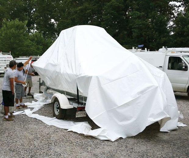 Staff at Diversified Marine Services in Annapolis shrinkwrapping a boat on its trailer.