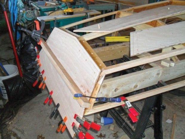 The transom, already screwed in position, is shown clamped tightly in place to the boat’s framing until the glue sets. Photo by Karl Nisson