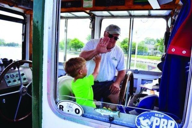 Capt. Tom Bixler gives 4-year-old passenger Nathan a high five after Nathan brought the ferry into the dock (with a little help from the captain).