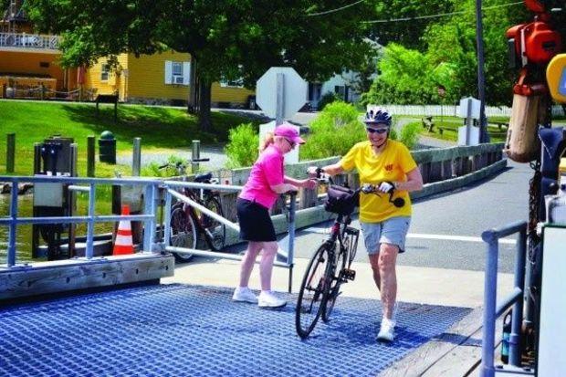 Bicyclist Diana Headlee makes the ferry in the nick of time. Judy Bixler closes the gate behind her.