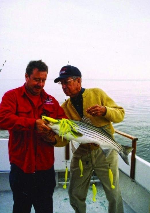 Captain Bud Harrison on the left helps a customer with his trophy rockfish.