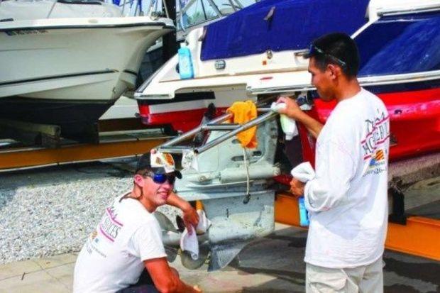 Dean's Yacht Service employees Bailey Leconte and Javier Peret prepare a runabout to go back in the water at Jabin's Yacht Yard in Annapolis. Photo by Rick Franke