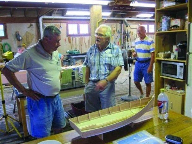 Museum shipwright George Surgent (center) and volunteers Al Suydam (left) and Bill Wright reviewing the scale model of the proposed electric-powered crab scrape at the Calvert Marine Museum boatshop in Solomons, MD. Photo by Butch Garren