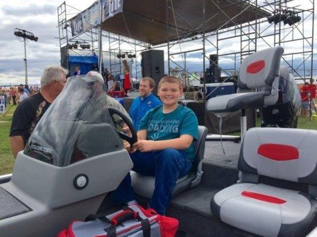 Grand prize winner, 12-year-old Luke Adams, with his new boat.