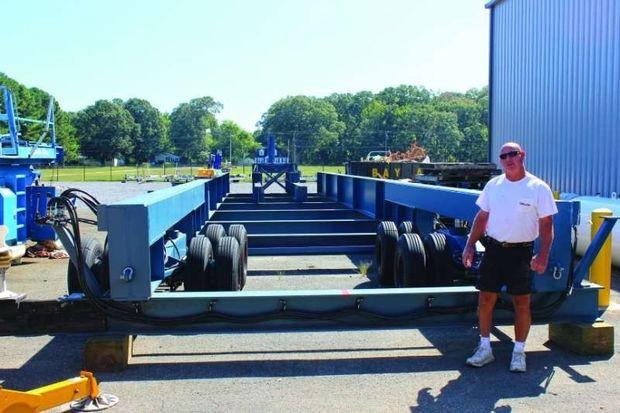 Jim Weaver with the company's custom built boat trailer in Deale, MD. The trailer is used to truck completed boats across Rockhold Creek for launching. Photo by Rick Franke
