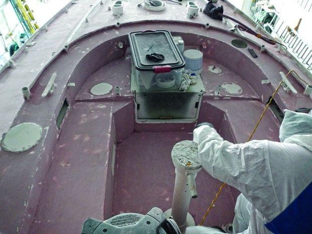 Painstaking surface preparation is the key to a glossy finished paint job on an aluminum boat at Hartge Yacht Harbor in Galesville, MD.