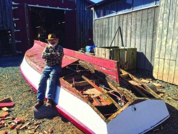 Chesapeake Bay Maritime Museum volunteer Austin Womblsey of Rock Hall, MD, takes a break after working to remove deteriorated wood from the 1961 tuck stern Pot Pie skiff.